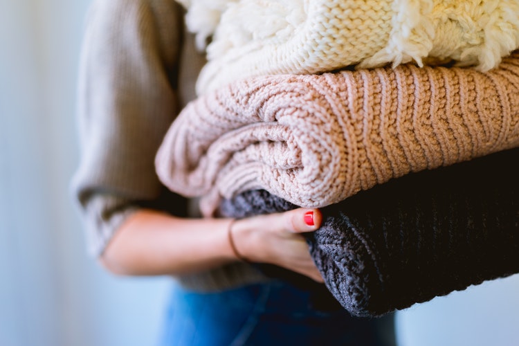 ide foto musim gugur untuk instagram - seorang gadis dengan sweter terlipat di tangannya